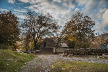 Terk edilmiş eski bir ev. Kışın gün batımında ormanda. Ormanın ortasında, güneşin sıcak ışınlarında terk edilmiş bir av kulübesi. Azerbaycan Köyü