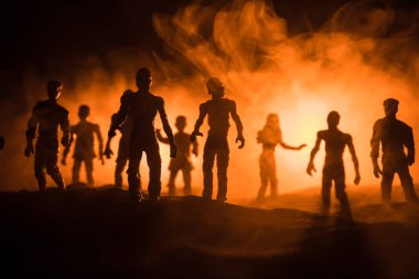 Bulutlu gökyüzü ve sis ile mezarlıktaki zombilerin korkunç görüntüsü, Korku Cadılar Bayramı konsepti. Seçici odak