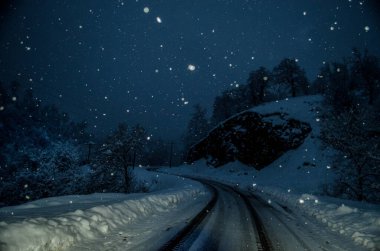 Dolunay gecesi karlı ormanda Dağ Yolu. Ay ve yıldızlı, koyu mavi gökyüzü manzaralı gece manzarası. Azerbaycan
