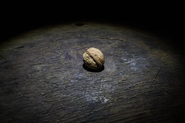 Fındık yemeği konsepti. Ceviz çekirdekleri ve eski ahşap masadaki cevizlerle dolu bir hayat. Yaratıcı masa dekorasyonu. - Yakın çekim. Seçici odak