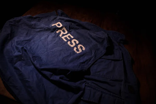Media Journalism Global Daily News Content Concept. Blue journalist (press) vest in dark with backlight and fog. Selective focus