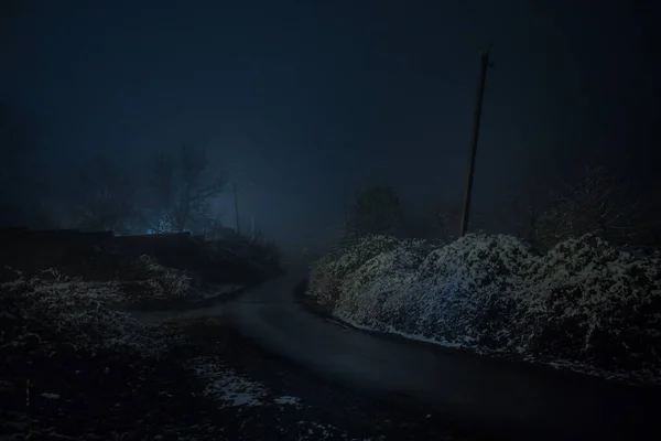 Mountain Road through the snowy forest on a full moon night. Scenic night winter landscape of dark blue sky with moon and stars. Azerbaijan