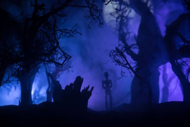 Kana susamış zombiler konsepte saldırıyor. Geceleri ölü ormanda yürüyen korkunç zombi silueti. Yaratıcı masa dekorasyonları. Seçici odak