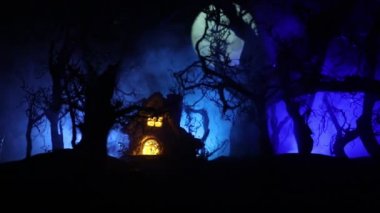 Dolunay sırasında sisli bir gecede bataklıktaki ağaç siluetlerini gösteren ürkütücü karanlık bir manzara.