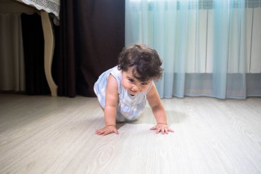 Yazlık Giysili Bebek Odanın içinde ahşap zemine otur. Pencerenin yanında oturan küçük kız.