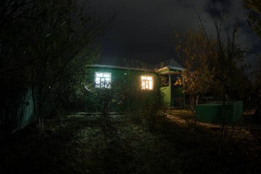 Geceleri ormanda bir hayaletin olduğu eski bir ev ya da terk edilmiş bir korku evi. Ölü ağaç ormanındaki eski mistik bina. Gerçeküstü ışıklar. Korku Cadılar Bayramı konsepti