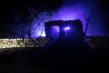 Geceleri terk edilmiş bahçedeki eski harabe taş ev. Ölü ağacı ve sisli arka lambası olan terk edilmiş eski mistik bir bina. Seçici odak