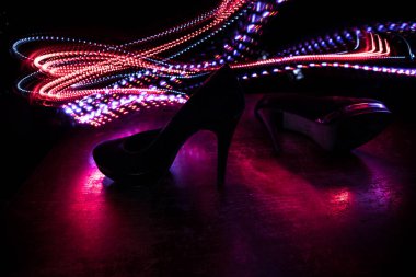 Sanat dekorasyonu. Karanlıkta topuklu kadın ayakkabılarının silueti. Kadın gücü ya da kadın egemenliği kavramı. Seçici odak