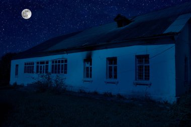 Sisli bir gecede ormanda bir hayaletin olduğu eski bir ev ya da House 'un ayın altında olduğu bir gece sahnesi. Ölü ağaç ormanındaki eski mistik bina..