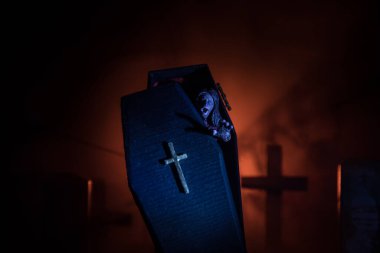 Yaratıcı sanat eserleri. İçinde zombi olan minyatür tahta tabut. Mezarlıktaki korkunç zombi manzarası. Korku Cadılar Bayramı konsepti. Seçici odak