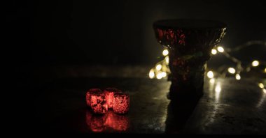 Yakıcı kömür küplerine yakın çekim. Başla. Nargile içtikleri için kasede yanan közler. Karanlık arka planda yaratıcı sanat eserleri. Boşluk. Seçici odak