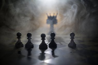 Satranç tahtasında güzel bir taç minyatürü. Satranç masası iş fikirleri, rekabet ve strateji fikirleri konsepti. Duman ve sisli karanlık bir arka planda satranç figürleri. Seçici odak