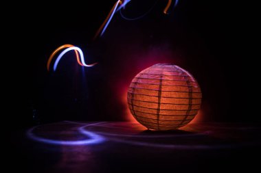 Karanlıkta ahşap masada parlayan güzel kağıt fener. Seçici odak