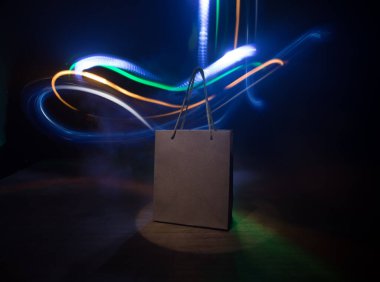 Alışveriş konsepti. Koyu renk masaüstüne saplı kahverengi alışveriş çantası. Seçici odak