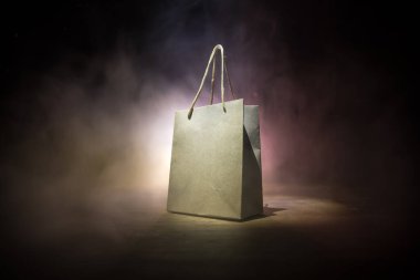 Alışveriş konsepti. Koyu renk masaüstüne saplı kahverengi alışveriş çantası. Seçici odak