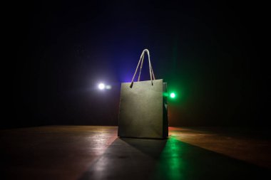 Alışveriş konsepti. Koyu renk masaüstüne saplı kahverengi alışveriş çantası. Seçici odak