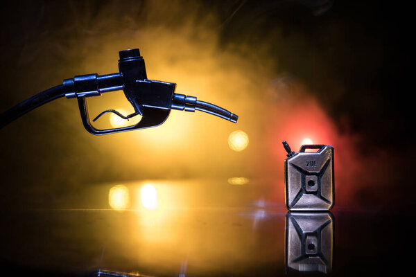 Творческая концепция. Силуэт миниатюры бензинового пистолета на темно-тонированном туманном фоне. Закрывай. Промышленные декоративные элементы на заднем плане. Селективный фокус