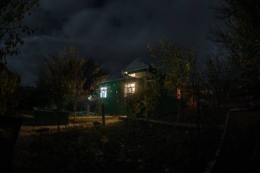 Geceleri ormanda bir hayaletin olduğu eski bir ev ya da terk edilmiş bir korku evi. Ölü ağaç ormanındaki eski mistik bina. Gerçeküstü ışıklar. Korku Cadılar Bayramı konsepti