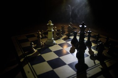 Fikirler, rekabet ve strateji için satranç tahtası oyunu, iş başarısı konsepti. Karanlıkta satranç figürleri. Seçici odak