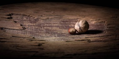 Fındık yemeği konsepti. Ceviz çekirdekleri ve eski ahşap masadaki cevizlerle dolu bir hayat. Yaratıcı masa dekorasyonu. - Yakın çekim. Seçici odak