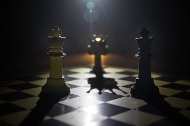 Satranç tahtasında güzel bir taç minyatürü. Satranç masası iş fikirleri, rekabet ve strateji fikirleri konsepti. Duman ve sisli karanlık bir arka planda satranç figürleri. Seçici odak