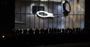 Halk ve polis gücü kavramı. Kalabalık hapishane minyatürüne bakıyor. Yaratıcı sanat dekorasyonu. Seçici odak.