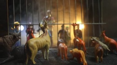 Kafesin içindeki bir grup hayvan minyatür. Hayvanat bahçesi konseptinde vahşi hayvanlar. Yanan renkli bir arka plan. Seçici odak