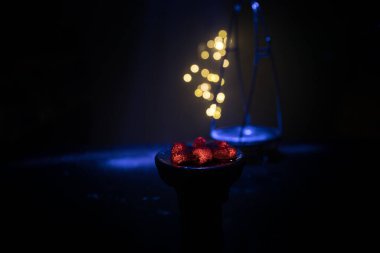 Yakıcı kömür küplerine yakın çekim. Başla. Nargile içtikleri için kasede yanan közler. Karanlık arka planda yaratıcı sanat eserleri. Boşluk. Seçici odak