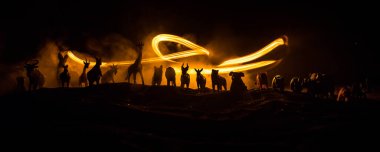 Bir grup hayvan sisli bir gecede yanan renkli bir geçmişle bir araya gelir. Hayvanlar hayatlarını ateşten kurtarmak için kaçıyorlar. Seçici odak.