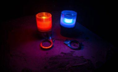 Gece polis baskını ve sen tutuklusun. Puslu arka planda yanıp sönen kırmızı ve mavi polis ışıkları olan kelepçelerin silueti. Seçici odak