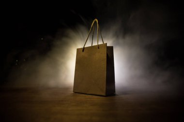 Alışveriş konsepti. Koyu renk masaüstüne saplı kahverengi alışveriş çantası. Seçici odak