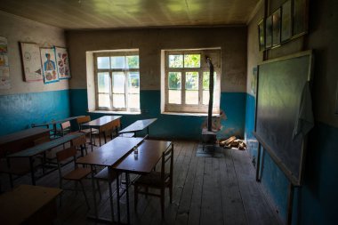 Eski ve terk edilmiş sınıf içi. Pencereleri ve masaları olan pis bir grunge odası. Seçici odak