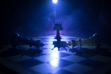 Satranç tahtasında güzel bir taç minyatürü. Satranç masası iş fikirleri, rekabet ve strateji fikirleri konsepti. Duman ve sisli karanlık bir arka planda satranç figürleri. Seçici odak