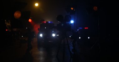 Minyatür film sahnesinin kamera ışığı ve polis arabalarıyla yakın çekim görüntüleri.
