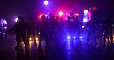 Çevik kuvvet polisi hazır olmak için işaret verdi. Hükümetin güç kavramı. Özel harekat polisi iş başında. Karanlık arka planda ışıklarla tüttürmek. Mavi kırmızı yanıp sönen sirenler. Seçici odak