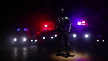 Çevik kuvvet polisi hazır olmak için işaret verdi. Hükümetin güç kavramı. Özel harekat polisi iş başında. Karanlık arka planda ışıklarla tüttürmek. Mavi kırmızı yanıp sönen sirenler. Seçici odak