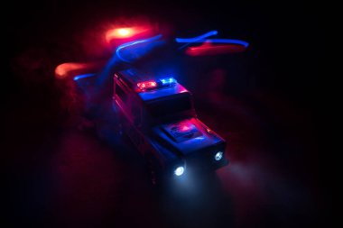 Polis arabası sisli bir arabayı gece takip ediyor. 911 acil durum arabası suç mahalline doğru hızla gidiyor. Yaratıcı dekorasyon. Seçici odak