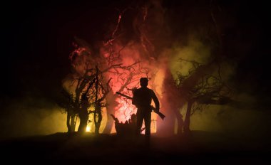 Zombi saldırısına karşı silahlı bir adam. Zombi kıyameti. Ormandaki bulanık zombilerin korkunç görüntüsü ve sisli, ürkütücü bulutlu gökyüzü. Korku Cadılar Bayramı konsepti.