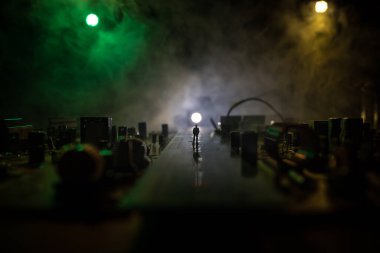 Elektronik bir cihazın içindeki modern teknolojinin yaratıcı konsepti. İnsan minyatürü mikro devrede duruyor. Elektronik devre kartı sade bir şekilde kapanır. Seçici odak