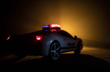 Polis arabası sisli bir arabayı gece takip ediyor. 911 acil durum arabası suç mahalline doğru hızla gidiyor. Yaratıcı dekorasyon. Seçici odak
