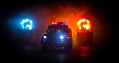 Polis arabası sisli bir arabayı gece takip ediyor. 911 acil durum arabası suç mahalline doğru hızla gidiyor. Yaratıcı dekorasyon. Seçici odak