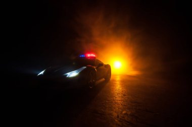 Polis arabası sisli bir arabayı gece takip ediyor. 911 acil durum arabası suç mahalline doğru hızla gidiyor. Yaratıcı dekorasyon. Seçici odak