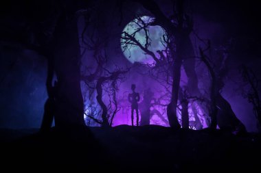 Kana susamış zombiler konsepte saldırıyor. Geceleri ölü ormanda yürüyen korkunç zombi silueti. Yaratıcı masa dekorasyonları. Seçici odak