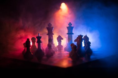 Satranç tahtasında güzel bir taç minyatürü. Satranç masası iş fikirleri, rekabet ve strateji fikirleri konsepti. Duman ve sisli karanlık bir arka planda satranç figürleri. Seçici odak