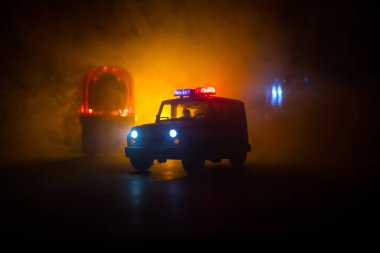 Polis arabası sisli bir arabayı gece takip ediyor. 911 acil durum arabası suç mahalline doğru hızla gidiyor. Yaratıcı dekorasyon. Seçici odak