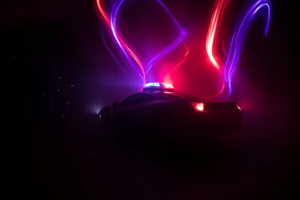 Police car chasing a car at night with fog background. 911 Emergency response police car speeding to scene of crime. Creative decoration. Selective focus