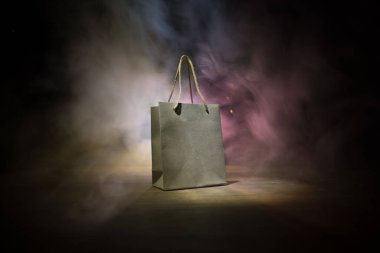 Alışveriş konsepti. Koyu renk masaüstüne saplı kahverengi alışveriş çantası. Seçici odak