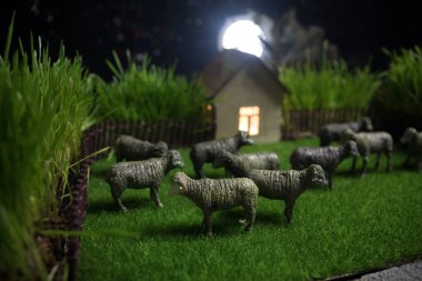 Çiftlikteki koyunlar. Çiftlik (köy) yaşam konsepti. Geceleri dekoratif oyuncak figürleri. Seçici odak