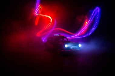 Polis arabası sisli bir arabayı gece takip ediyor. 911 acil durum arabası suç mahalline doğru hızla gidiyor. Yaratıcı dekorasyon. Seçici odak