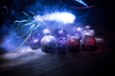 Sebze konsepti. Karanlıkta farklı soğanlar. Seçici odaklanma. Renkli arkaplan.